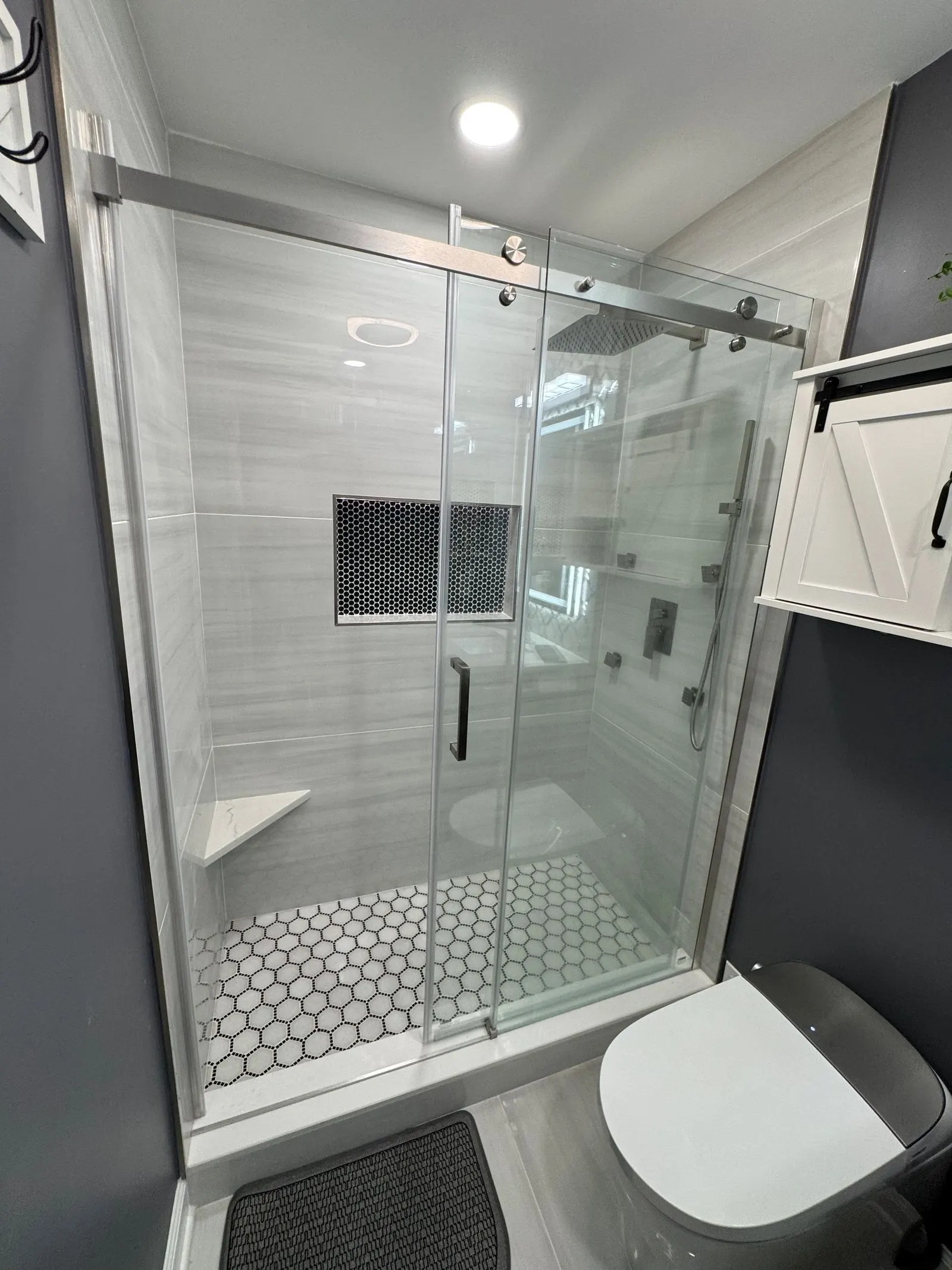 Walk-in glass shower with hexagon floor tile